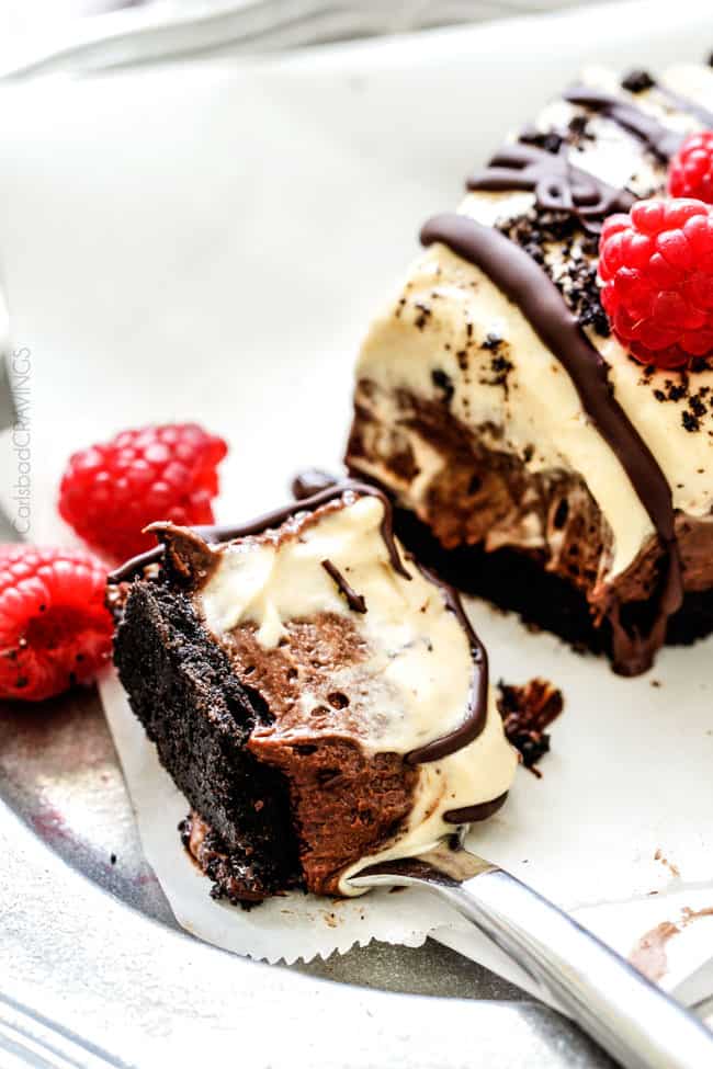 A bite of Peanut Butter Chocolate Mousse on a plate with raspberries on a fork. 