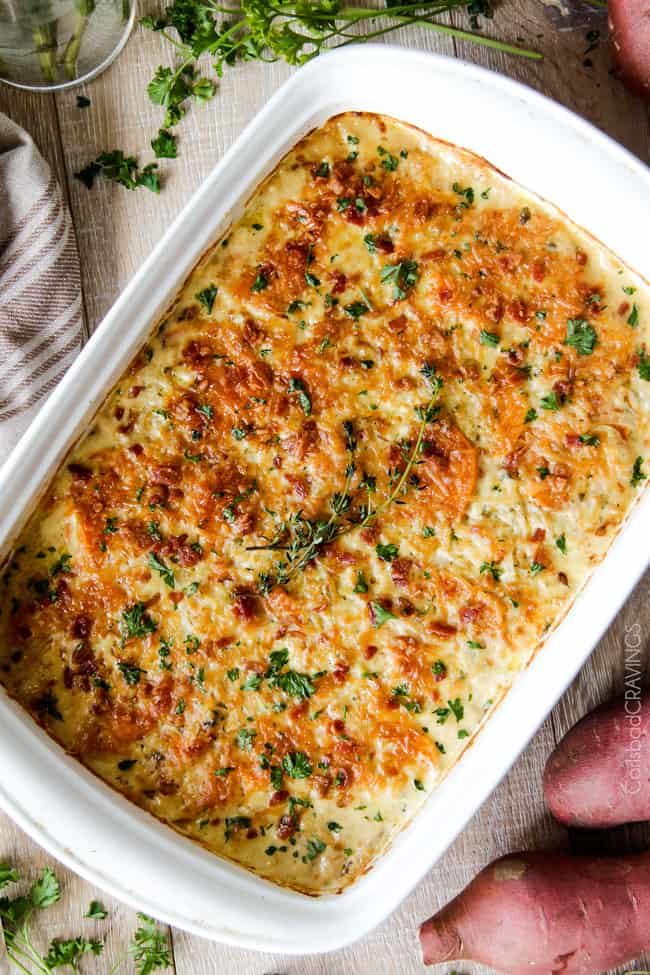 Looking for the BEST scalloped sweet potatoes ever EVER?! Fresh herbs simmered in cream poured over layers of potatoes, bacon and onions topped with Gruyere cheese. Perfect for Thanksgiving, company or every day!