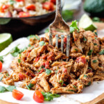 Easy Slow Cooker Shredded Mexican Chicken simmered with Mexican spices, salsa and green chilies for the BEST Mexican chicken perfect for tacos, burritos, tostadas, salads, etc. Couldn’t be any easier!