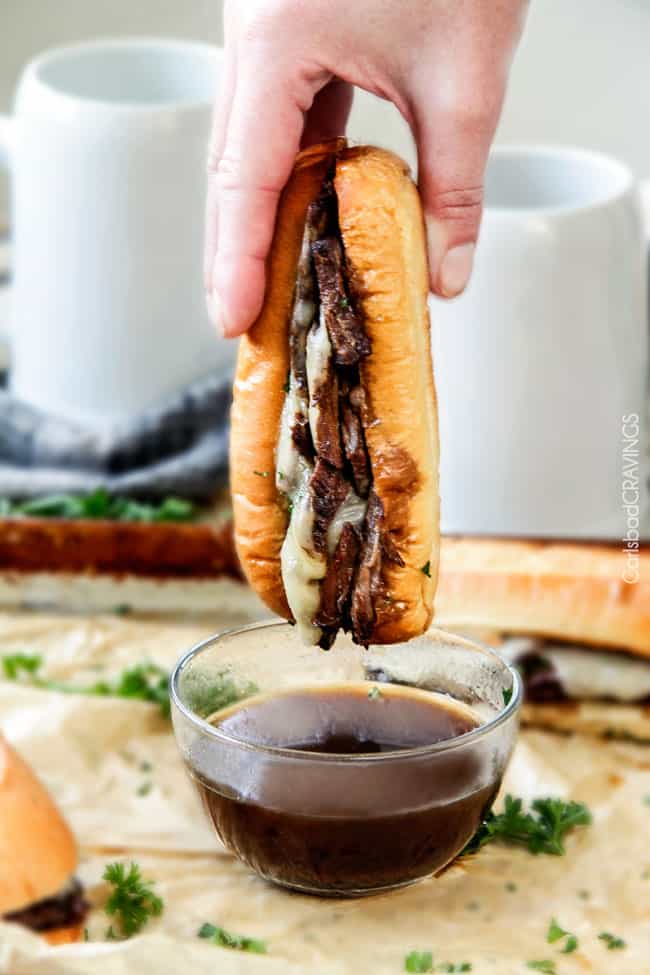 Crock pot French Dip Sandwich being dipped in and dripping with au jus