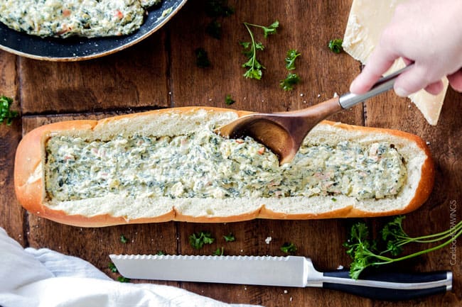 Showing how to make Spinach Dip Stuffed French Bread melted adding cheeses to the bread