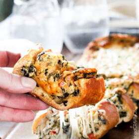 Easy Spinach Dip Stuffed French Bread is your favorite cheesy dip baked right into the loaf! Crazy delicious side or easy crowd pleasing appetizer!