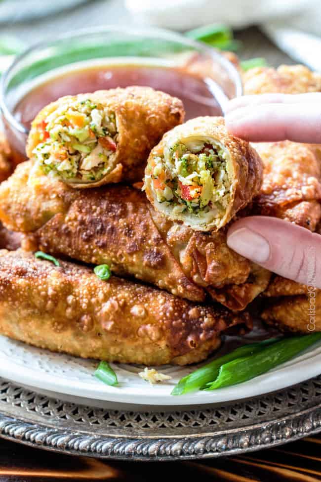 up close of a hand picking up a Chinese chicken egg roll