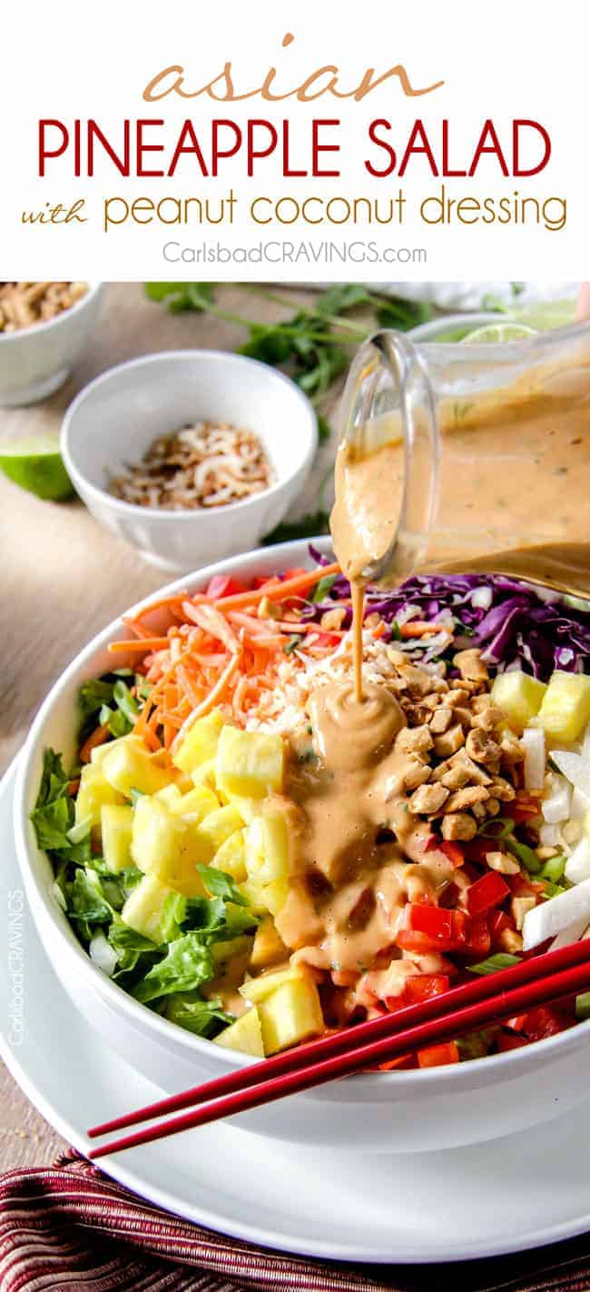 Peanut dressing being poured over a thai salad. 