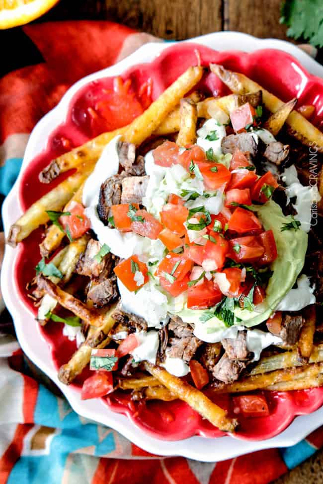 Forget the nachos, these Loaded Carne Asada Fries are so addictingly delicous! baked Mexican spiced French fries smothered in cheese and piled high with tender juicy steak, salsa, avocado crema, etc.