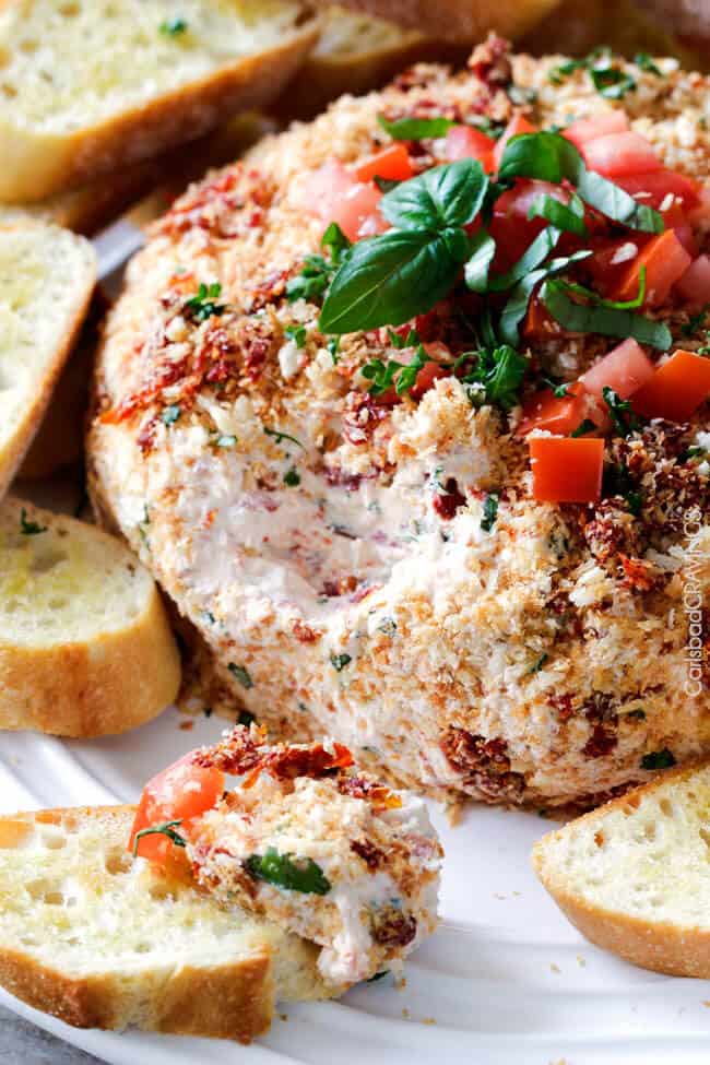 A close up shot of Bruschetta Cheese Ball with bread next to it.