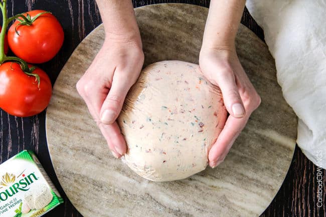 Showing how to make Bruschetta Cheese Ball by making it into the shape of a ball.