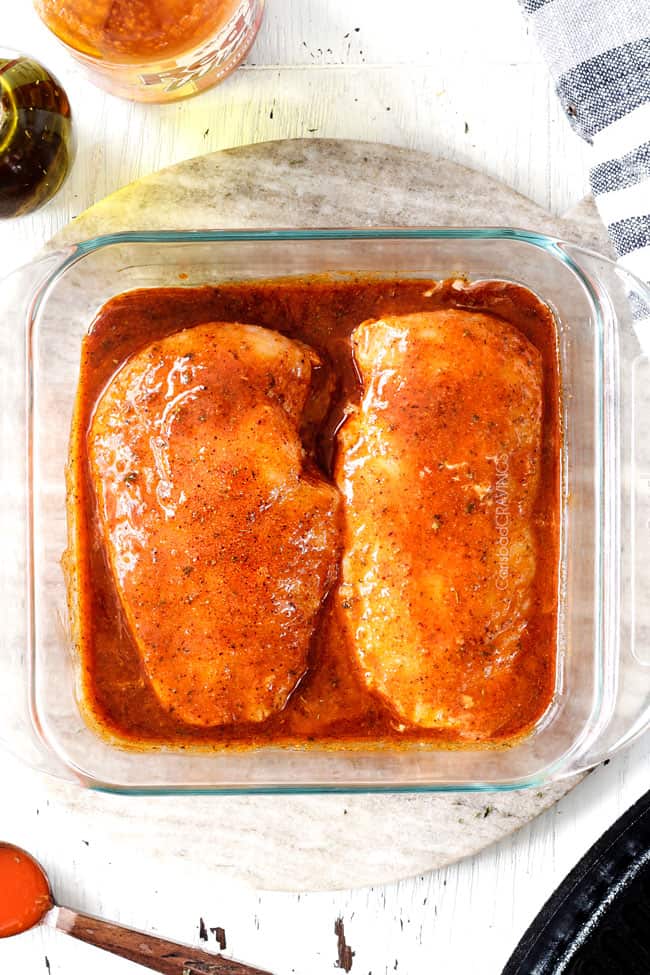Showing how to make Buffalo Chicken Recipe by marinating chicken in hot sauce