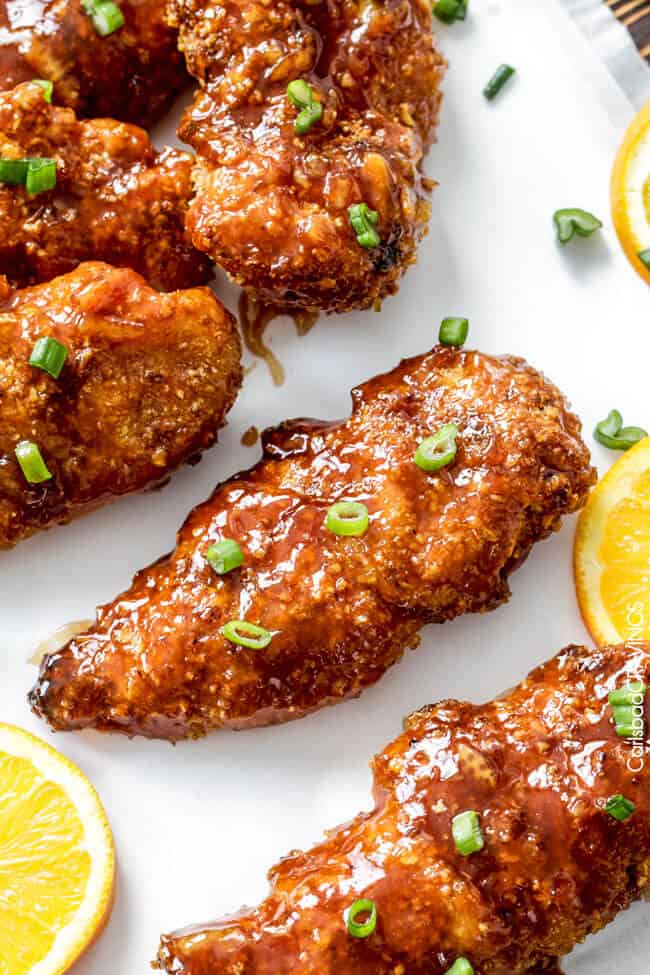 Sweet and Spicy Baked Orange Chicken Tenders with green onion garnish. 