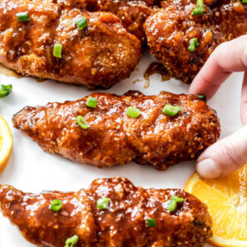 Tender, juicy Baked Orange Chicken Tenders are marinated and smothered in the most tantalizing sweet heat orange sauce you can't even imagine! You will crave this over your favorite Chinese orange takeout!