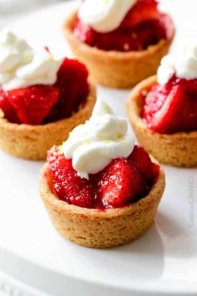 Close up of Mini Strawberry Pies with Sugar Cookie Crust with whipped cream on top.