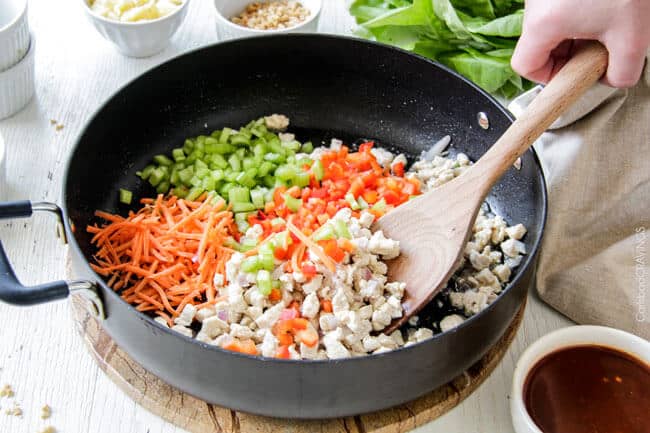 showing how to make Thai Chicken Lettuce Wraps by cooking chicken and veggies in a skillet