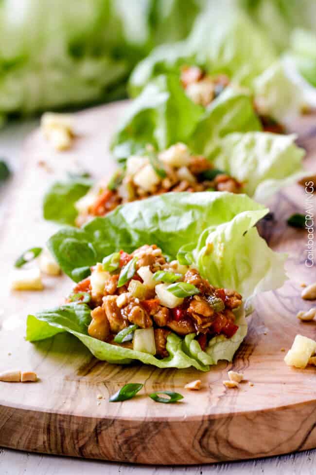 Quick and easy Asian Chicken Lettuce Wraps smothered in an unbelievable Pineapple Hoisin Peanut Sauce are 1000X better than takeout and on your table in under 30 minutes! 