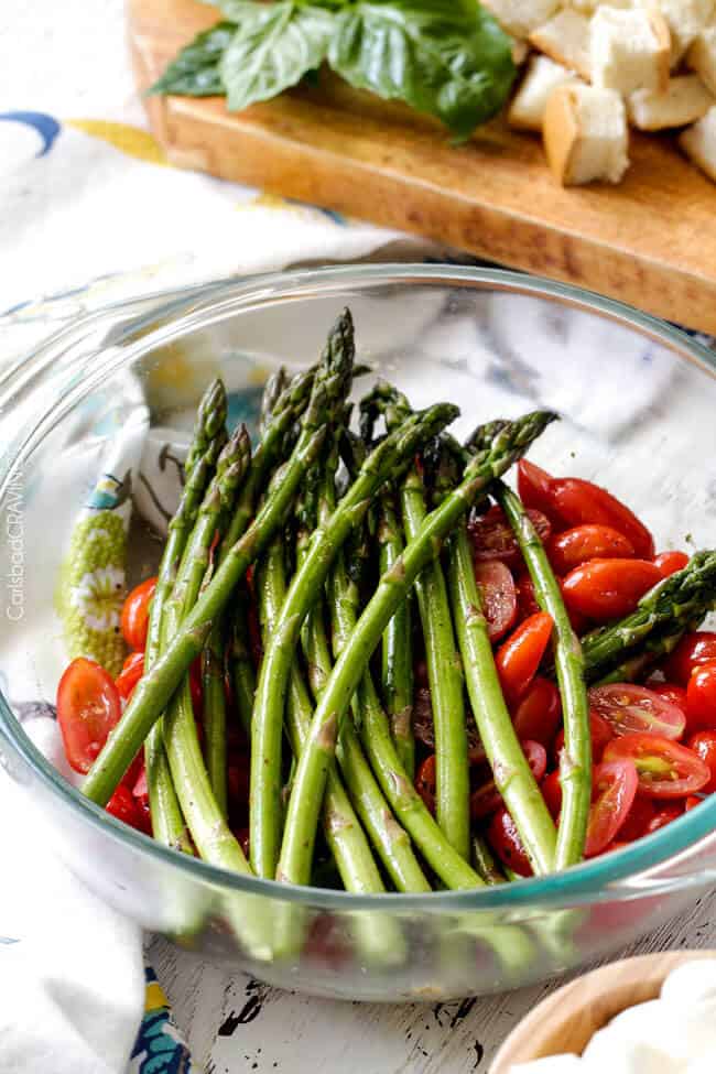 Showing how to make Caprese Chicken Salad by preparing tomatoes and asparagus. 