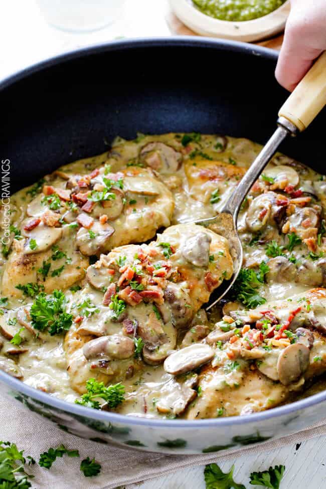 creamy chicken and mushroom sauce in a skillet with a serving spoon. 