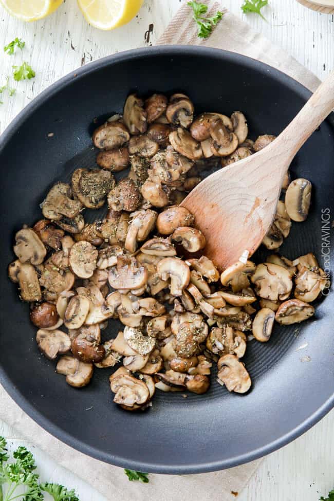 process shot showing how to make creamy mushroom sauce for chicken in a skillet. 