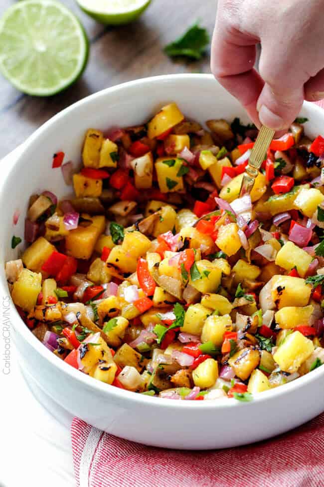 Mixing the Showing how to make Grilled Pineapple Pear Salsa.
