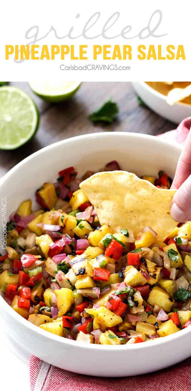 Grilled Pineapple Pear Salsa dipping a chip in.
