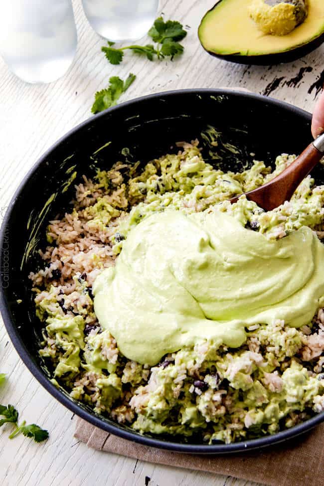 Showing how to make Creamy Cilantro Lime Avocado Rice by mixing the cream sauce in the rice. 