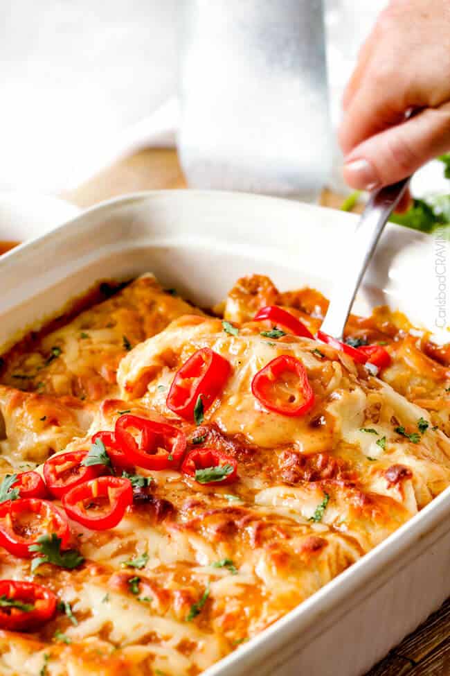 a spatula digging into chili enchiladas with sweet chili enchiladas