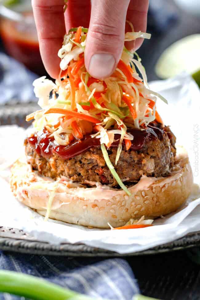 Adding the coleslaw to Asian Burger with Hoisin Ketchup & Garlic Chili Mayo