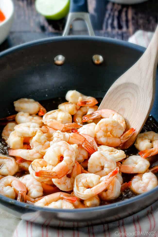 Showing how to make Sweet Chili Shrimp by cooking the shrimp in a pan. 