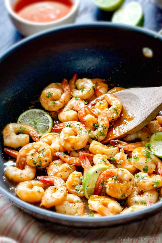 Showing how to make Sweet Chili Shrimp with lime garnish in a pan.