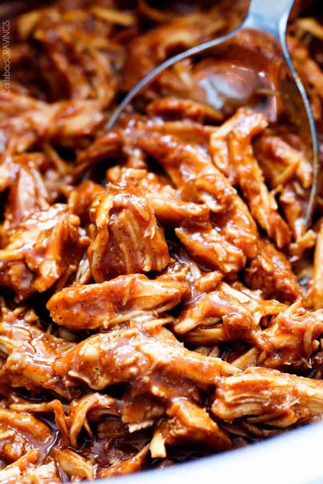 close up of crockpot bbq chicken with metal serving spoon