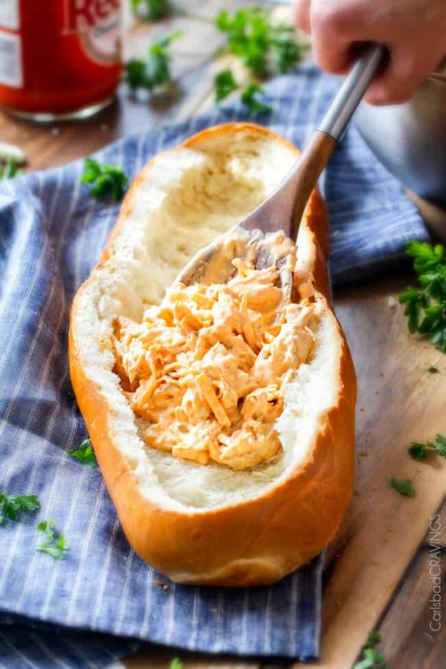 Showing how to add the filling to Buffalo Chicken Dip (Stuffed French Bread)
