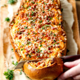 Mega flavorful Buffalo Chicken Dip Stuffed French Bread is your favorite cheesy dip baked right into the loaf! Crazy delicious side or EASY crowd pleasing appetizer! Everyone will be begging you to bring this!