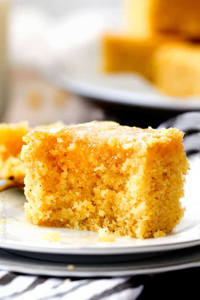 up close of a slice of Sweet Cornbread with a bite out of it on a white plate