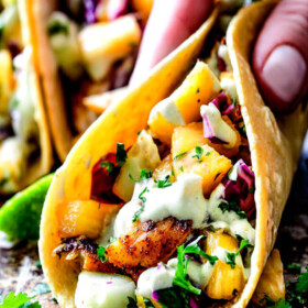 Mind blowing Blackened Fish Tacos with a quick marinade and the most flavorful spice rub! These are hands down the BEST FISH TACOS ever! And the sweet and tangy Pineapple Cucumber Slaw and Avocado Crema hit this one out of the park! seriously better than my favorite restaurant!