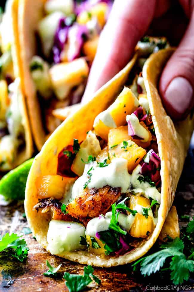 Mind blowing Blackened Fish Tacos with a quick marinade and the most flavorful spice rub! These are hands down the BEST FISH TACOS ever! And the sweet and tangy Pineapple Cucumber Slaw and Avocado Crema hit this one out of the park! seriously better than my favorite restaurant!
