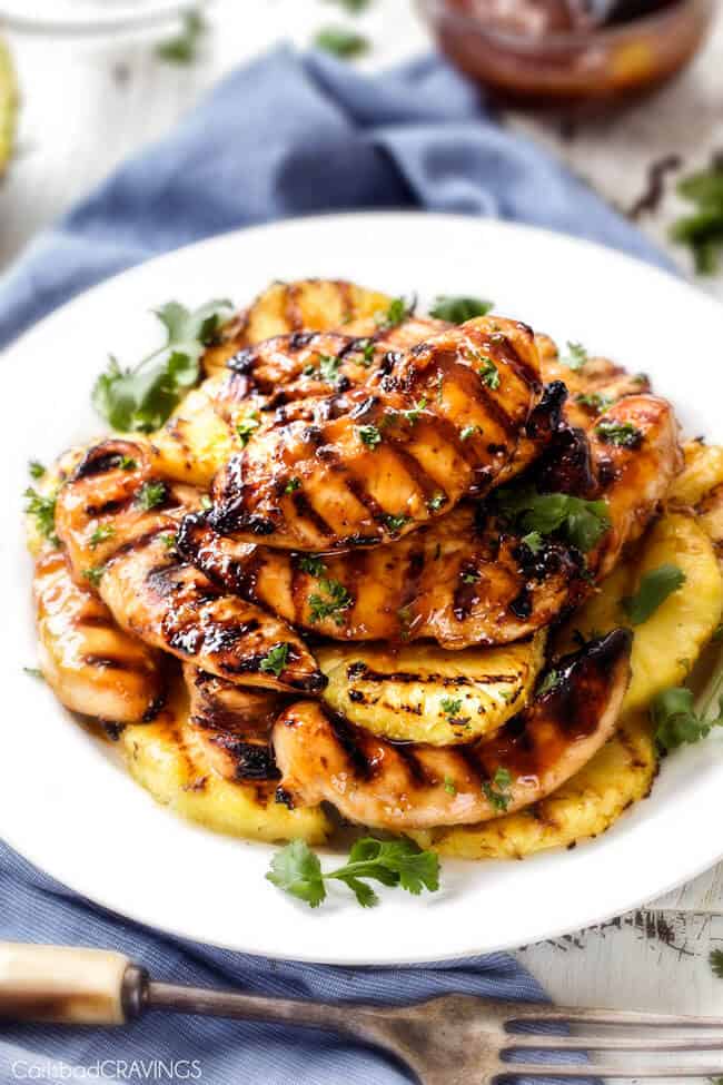 pile of pineapple chicken and grilled pineapple on white serving plate