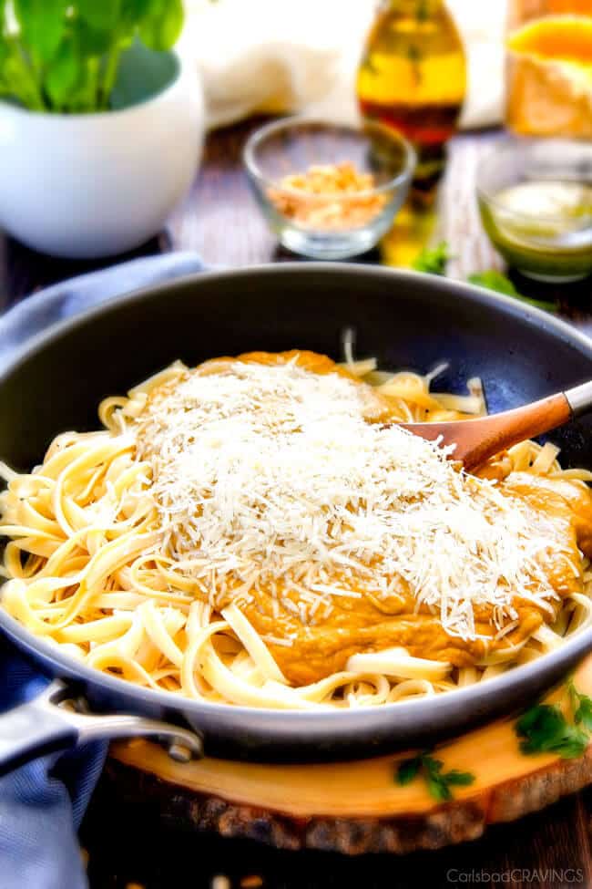 showing how to make Butternut Squash Pasta by adding Parmesan cheese to the butternut squash sauce