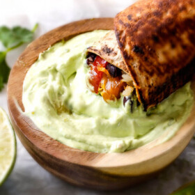 Chicken Fajita Wraps with Creamy Avocado Dip - layers of cheese, black beans, rice, the BEST chicken fajita filling, and sour cream all rolled up then skillet toasted for slightly crispy wraps that are absolutely addicting!! This is our family's favorite way to eat leftover chicken fajita filling!