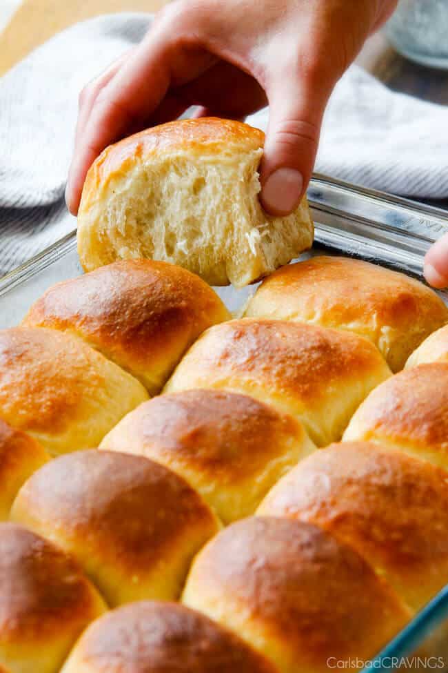 Hawaiian Sweet Rolls baked in a pan showing one pulling apart.
