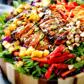 Teriyaki Chicken Salad - This salad is to live for! Packed with refreshing pineapple, macadamia nuts and coconut all doused with the most AMAZING Pineapple Sesame Dressing and the Sweet Chili Teriyaki Chicken is incredible! But my favorite part is you drizzle the leftover Teriyaki glaze all over the salad! Definitely a keeper!