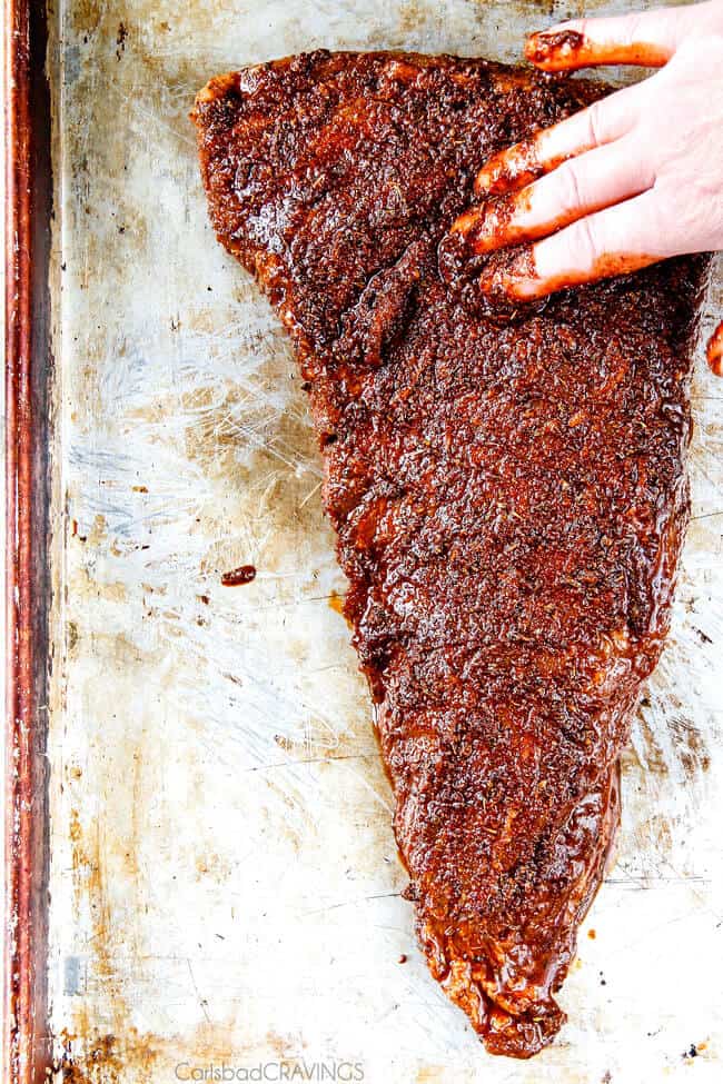 Showing how to make Cajun Steak with Apricot Orange Glaze by rubbing the steak. 