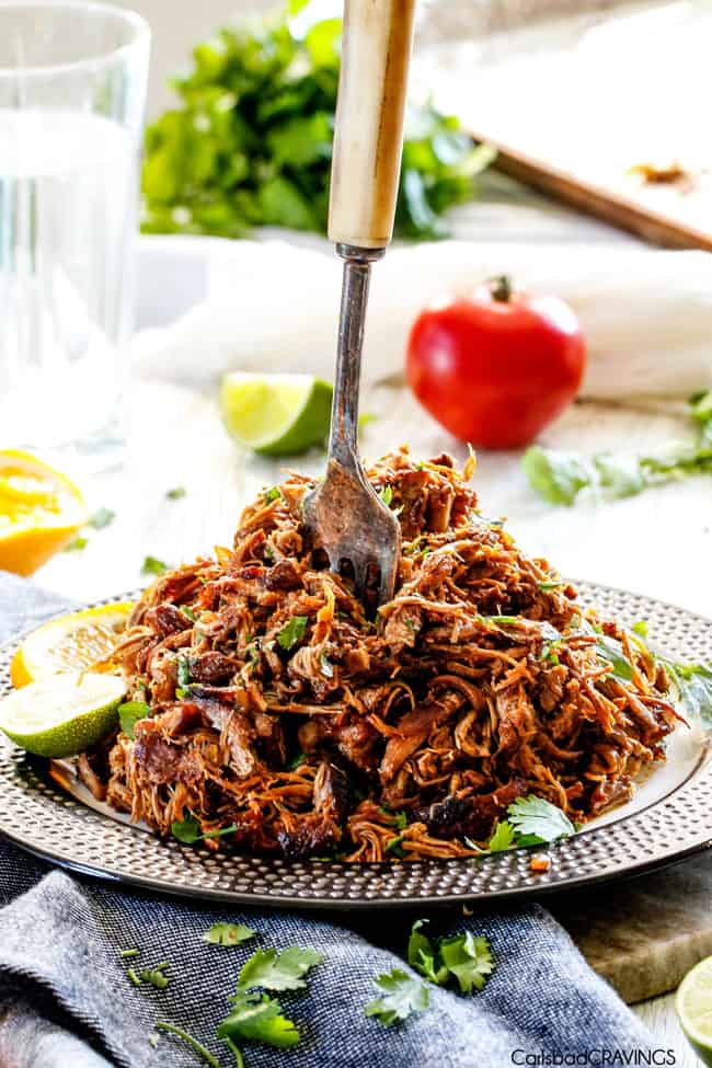 plate of pork carnitas with fork sticking out from middle