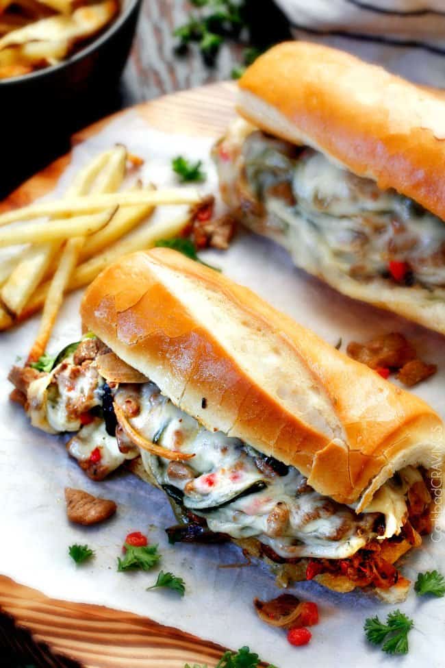 side view of easy Philly Cheesesteak recipe with the buns bursting with cheesy filling