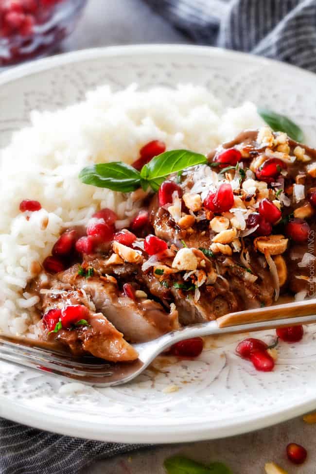 Close up of Asian Pomegranate Coconut Chicken Skillet with rice on a a plate. 