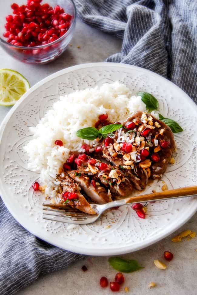 Asian Pomegranate Coconut Chicken Skillet on a white plate with rice. 