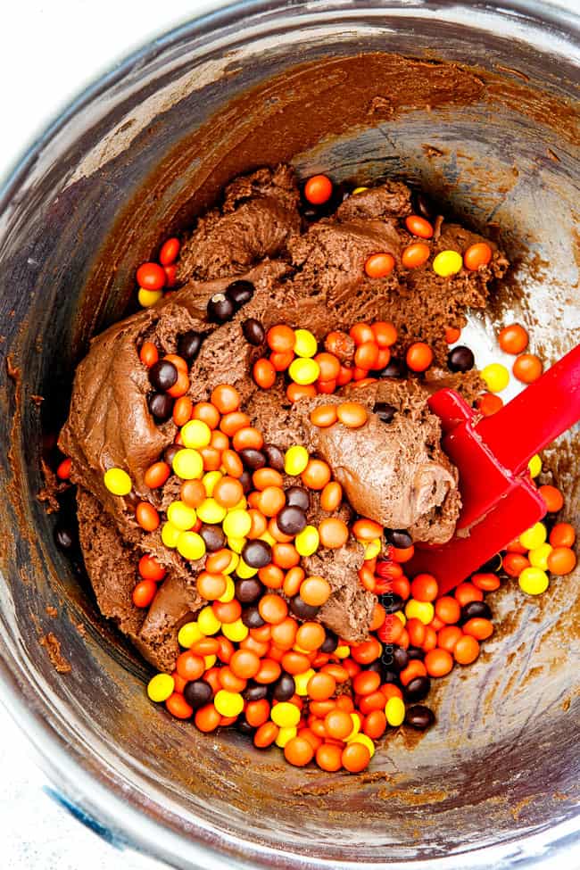 showing how to make easy nutella cookies by mixing reese's pieces into batter