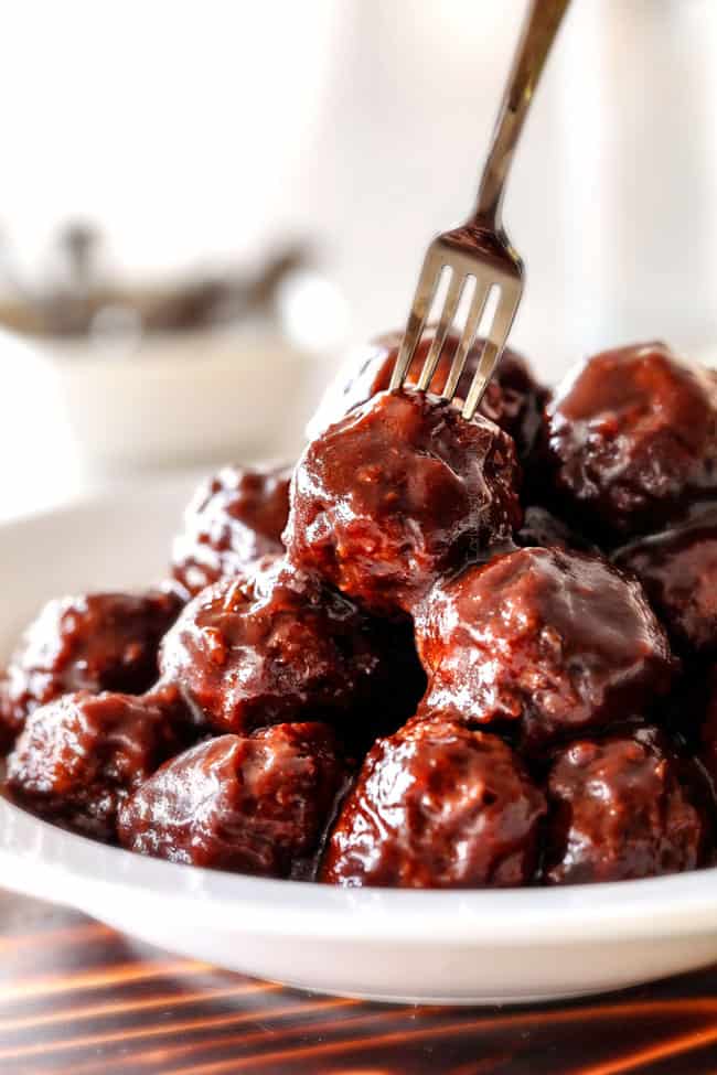 a plate of crockpot Korean Meatballs with Korean BBQ Sauce with a fork stabbing one of the meatballs