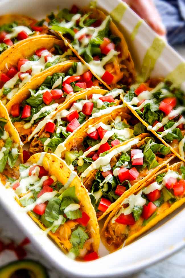 A baking pan full of Ranch Chicken Tacos piled with refried beans, cheese.