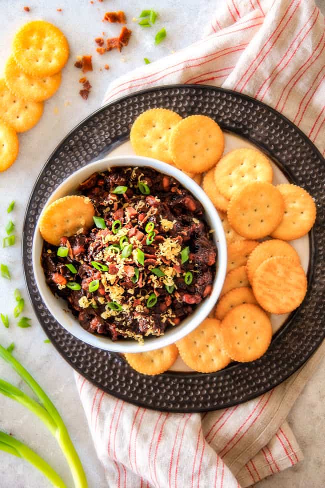 Boston Baked Bean Dip piled with bacon, cheese, sour cream, green onions with crackers on the side. .