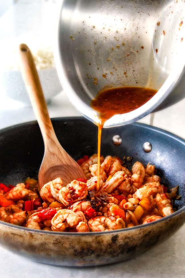 showing how to make Kung Pao Shrimp by adding Kung Pao Sauce to a skillet with shrimp