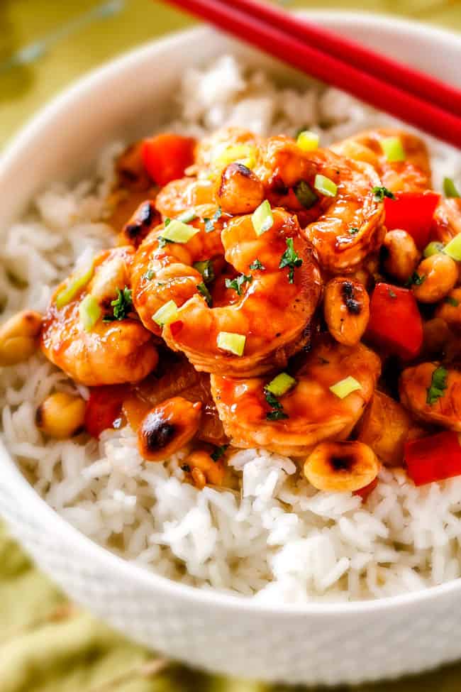 side view of healthy Kung Pao Shrimp with peanuts and bell peppers over rice