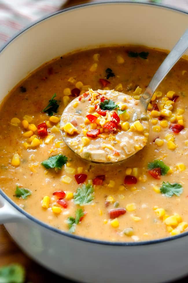 a ladle of Mexican Chicken Corn Chowder in a white dutch oven soup pot